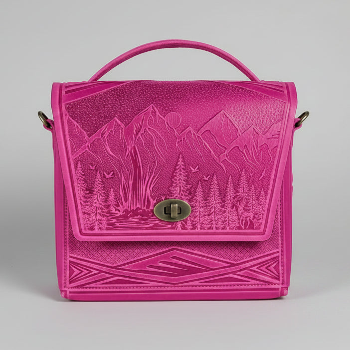 Pink embossed bag with nature design on a white brick wall background