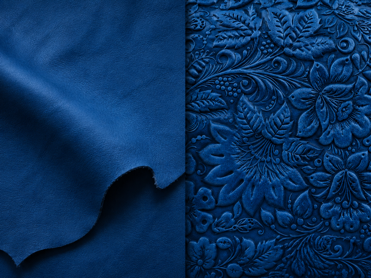 A close-up of deep blue leather fabric, split vertically: the left side shows smooth draped leather, and the right side shows an embossed floral pattern in a slightly darker blue tone.